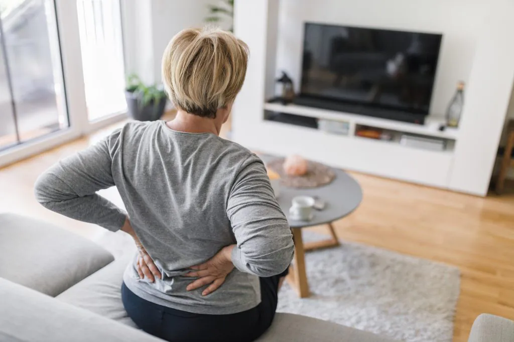 Elderly woman at home with back pain